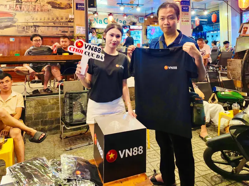 Anh em cược thủ quây quần tại bàn, dùng điện thoại quét mã QR hệ thống in sẵn trên bàn để nhận code trải nghiệm và liên kết tài khoản